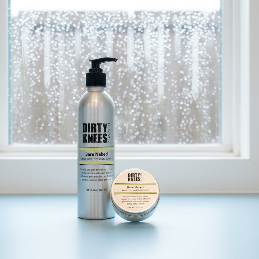 Two bottles of 'Dirty Knees' hair product on a white surface with a wooden floor in the background.